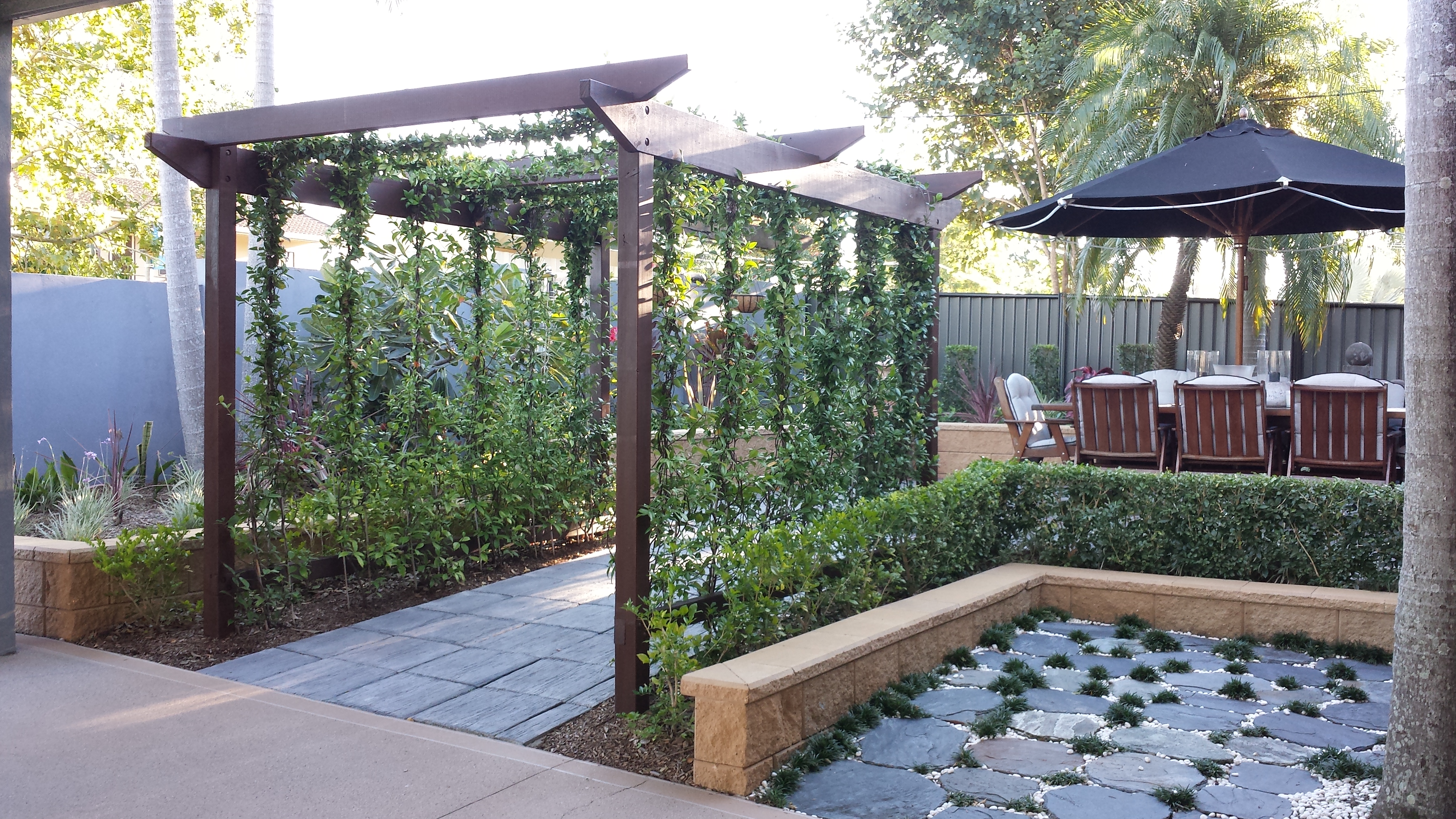 Concrete pavers with Jasmine vine arbour to entry